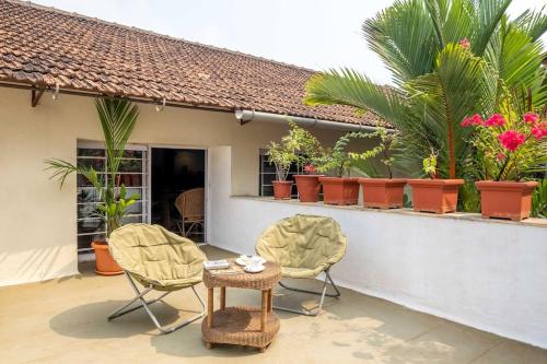 帕纳吉Nyara Fontainhas Panaji - Heritage villa Goa的庭院配有桌椅和植物