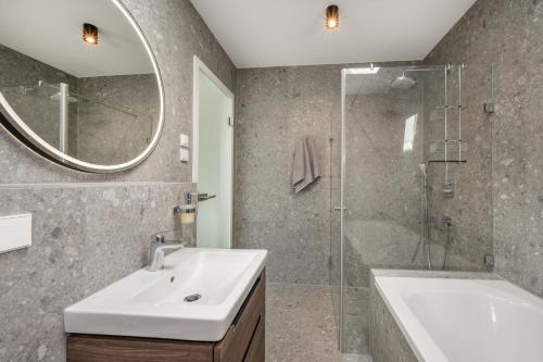 卢布明Lubminer Meerblick Apartments的浴室配有水槽、淋浴和浴缸。
