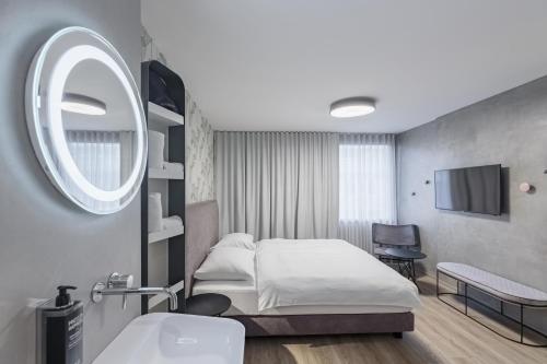 卢布尔雅那ibis Styles Ljubljana Centre的一间卧室配有床、水槽和镜子