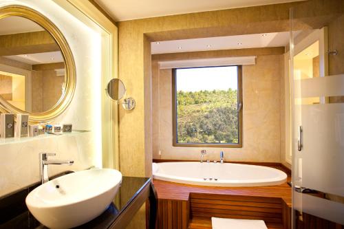 伊斯坦布尔利马克欧亚豪华酒店的带浴缸、水槽和窗户的浴室