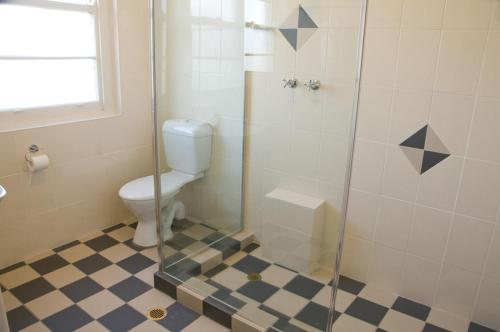 库马高山酒店的一间带卫生间和玻璃淋浴间的浴室