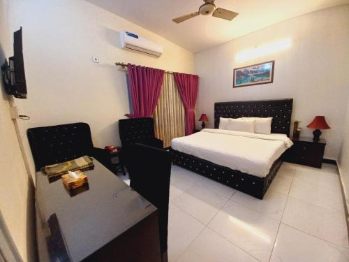 伊斯兰堡Travel Inn islamabad的一间卧室配有一张床和一张桌子