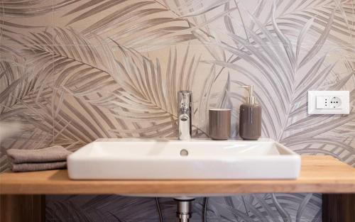 卡尔达罗Residence Hofgarten的墙壁上的浴室里设有一个白色水槽