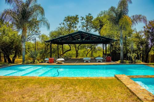 比勒陀利亚Mela Luxury Game Lodge的庭院中带凉亭的游泳池