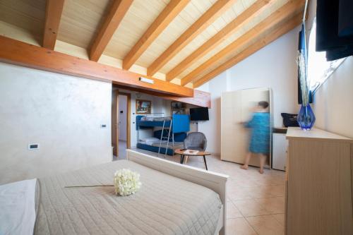 比比翁Casa Merano Residence & Ristorante Bibione Centro的卧室里有一床,房间里还有一位女士