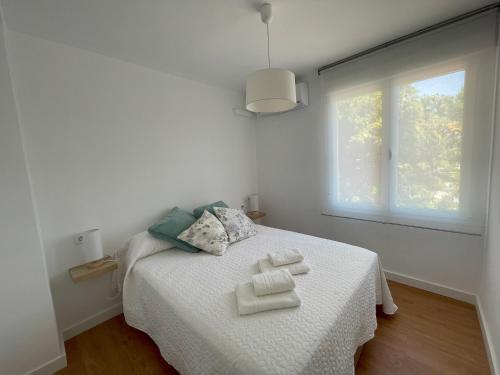 科尔多瓦Apartamento Colina B 19.的白色卧室配有带2条毛巾的床