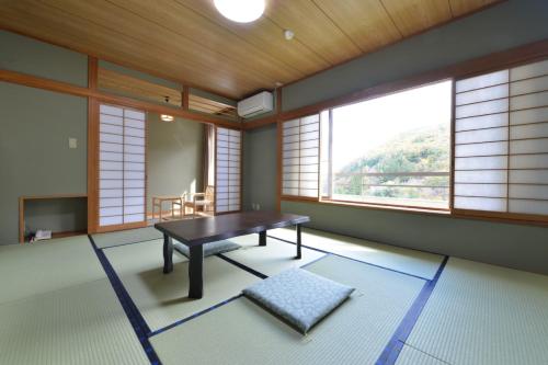 上田市Ooedo Onsen Monogatari Kakeyu的带桌子的客房位于带窗户的房间内