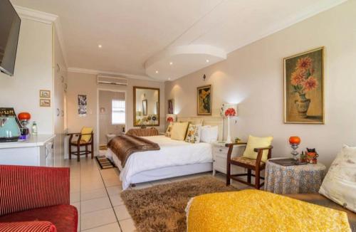 戈登湾Gordon's Beach Lodge的一间卧室设有一张床和一间客厅。