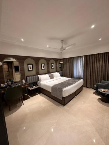 孟买滕伽国际酒店的一间大卧室,配有一张大床和一张书桌