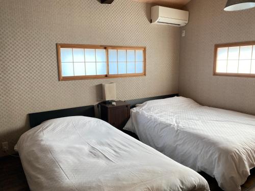 京都Samurai Suite 1 , 15mins from Kyoto Eki , 5 mins to Arashiyama的卧室设有两张床,带两个窗户