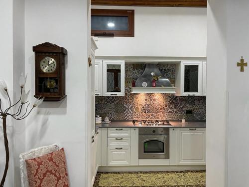 弗兰卡维拉丰塔纳Sasha House Casa Vacanze的厨房配有白色橱柜和墙上的时钟