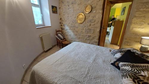 VénéjanLe Petit Cocon的一间卧室设有一张床和石墙