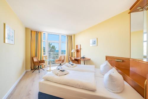 宾茨Arkona Strandhotel的酒店客房设有两张床和窗户。
