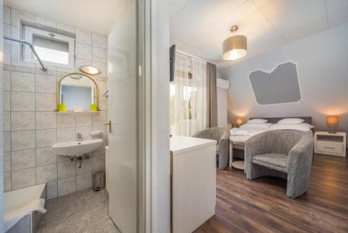 凯斯特海伊托卡耶尔康体酒店的一间带水槽的浴室和一间带一张床的卧室