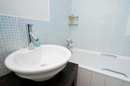 Eglwys-FâchBryn Rhydd的浴室配有白色水槽和浴缸。