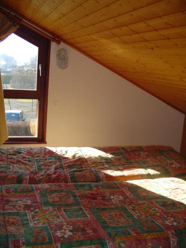VagneyLes Chalets Du Pres D'amont的一间卧室配有一张床,房间设有窗户