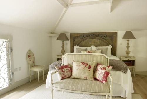 斯坦福德Rectory Cottage的一间卧室配有一张带椅子和枕头的床