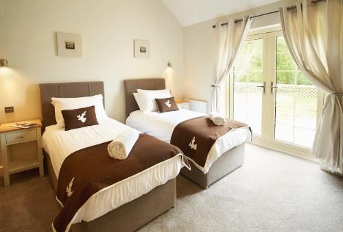 ChappelRamson Lodge的一间卧室设有两张床和窗户。