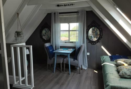 SlochterenB&B De Boeren Zwaluw的客房设有桌子、床和窗户。