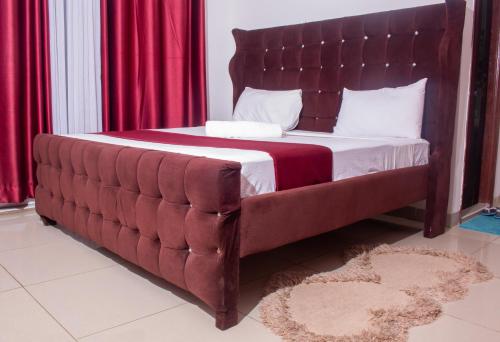 蒙巴萨Nyali 3 Bedroom Sea View Apartment的一张带大床头板和红色窗帘的床