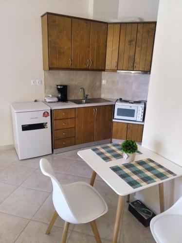 梅松吉New cozy sd No1 in Tzafi Apartments的厨房配有白色桌子和白色冰箱。