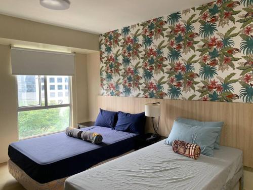 宿务Comfy Avida Cebu w/ Pool(2 adjoined units) 50MBPS的一间卧室设有两张床和鲜花墙