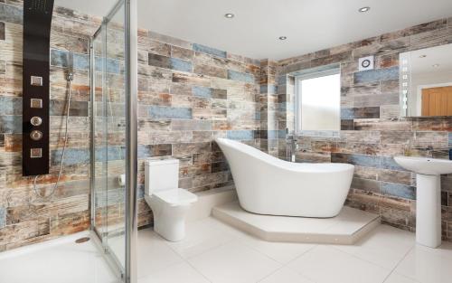 卡莱尔Stunning 1-Bed Cottage near Carlisle with Hot tub的带浴缸、卫生间和盥洗盆的浴室