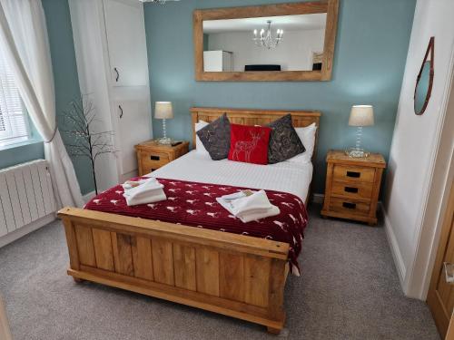 卡莱尔Stunning 1-Bed Cottage near Carlisle with Hot tub的一间卧室配有一张带红色枕头和镜子的床