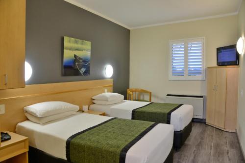 SouthgateRoad Lodge Southgate的酒店客房设有两张床和电视。
