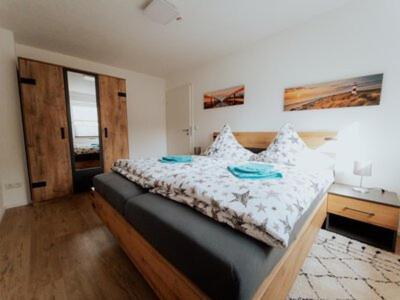 梅明根Welcome Haus Allgäu的一间卧室配有一张大床和木制床头板