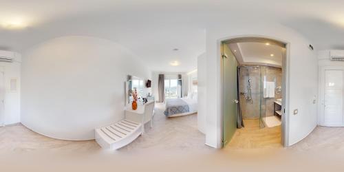 帕尔加Golden Lion Parga的一间白色客房,配有镜子和一间卧室