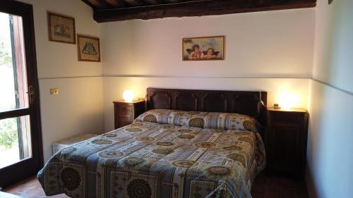 阿尔比尼娅洛坎达乐曼德利亚内酒店的一间卧室配有一张床、两盏灯和一个窗户。