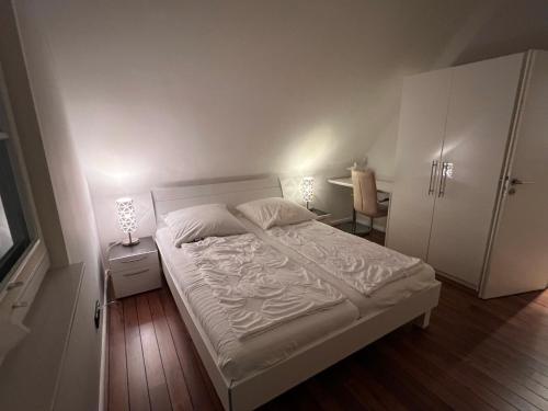 格洛韦Ferienhaus Sarcander的卧室配有白色的床、桌子和椅子