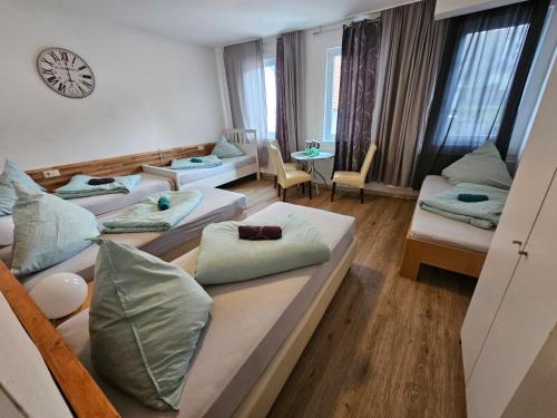 阿尔布斯塔特Hotel & Hostel Albstadt的一间设有四张床和枕头的客房