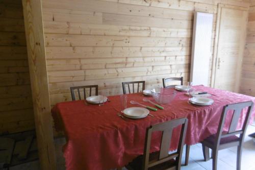 Saint-CômeChalet écologique en campagne bazadaise的餐桌、红色桌布和椅子