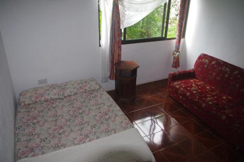 马埃岛木瓜别墅的卧室配有床、椅子和窗户。