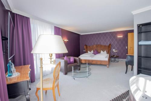 伊尔梅瑙Hotel Tanne Ilmenau的酒店客房,配有床和沙发