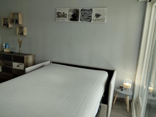 莱鲁斯Appartement les Rousses Bien situé的一张白色的床,位于带桌子的房间