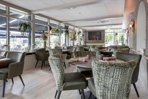 厄伊特霍伦 海特雷克特惠斯酒店的餐厅设有桌椅和窗户。