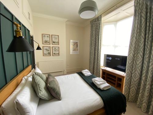 林肯Brayford House的一间卧室配有一张床、一台电视和一个窗口