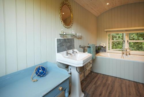 Anne's Hut Monmouthshire的浴室配有盥洗盆和浴缸。