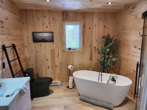 Saint ComeSpa calme au sommet的木墙浴室设有白色浴缸