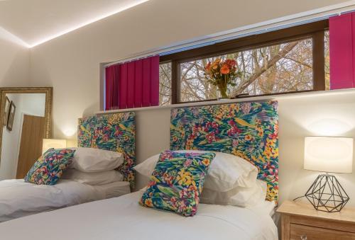 HoxneDownbridge Lodge的一间卧室设有两张床和窗户。