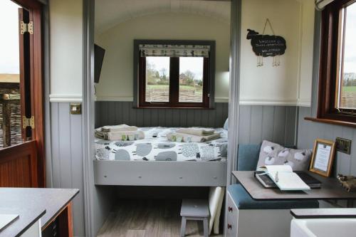 Spinney View Huts的小房间设有一张床和一张书桌