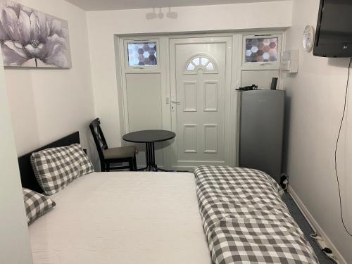 米尔顿凯恩斯Guest House in Milton Keynes的卧室配有床、桌子和门