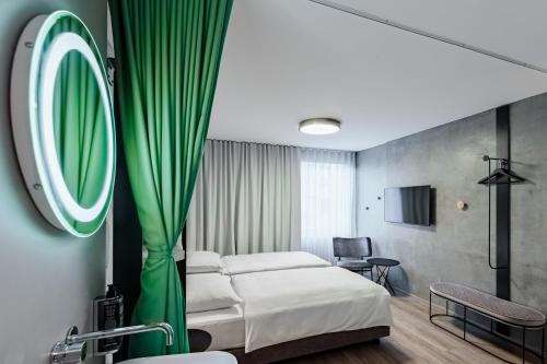 卢布尔雅那ibis Styles Ljubljana Centre的酒店客房,配有床和镜子