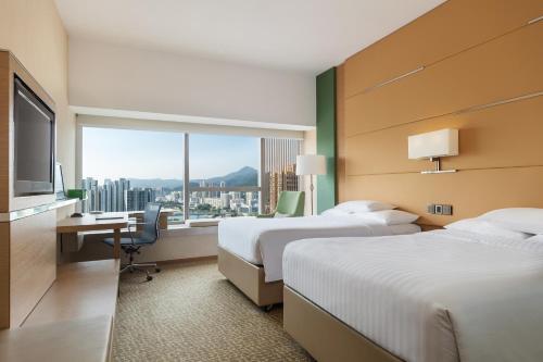 香港香港沙田万怡酒店的酒店客房设有两张床、一张书桌和一个窗户。