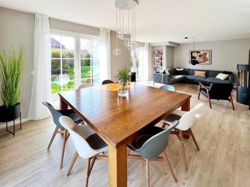 格罗斯施旺湖"Sonnenliebe" Ferienhaus的用餐室以及带木桌和椅子的客厅。
