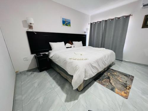 马翁Maun Nest Hotel的一间卧室配有一张带白色床单的大床