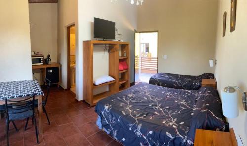 费德拉西翁Apart hotel la soñada的客房设有两张床、一张桌子和一张书桌。